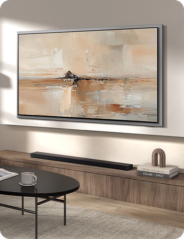 벽에는 TV가 설치되어 있으며, TV 아래에는 사운드바가 놓인 장식장이 있습니다. 장식장 앞에는 테이블이 있으며, 그 위에는 찻잔이 놓여 있습니다.