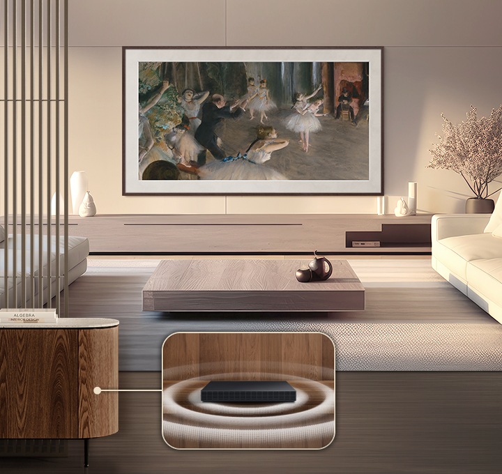 거실 벽에 플랫 브라운 베젤이 장착된 The Frame Pro TV 가 설치되어 있습니다. 화면에는 명화가 보여지고 있습니다. TV 아래에는 화병이 놓인 장식장이 있습니다. TV 앞에는 테이블과 소파가 놓여 있습니다. 왼쪽에 있는 소파 옆으로 장식장이 있으며, 장식장 안에는 무선 원 커넥트가 들어가져 있습니다.