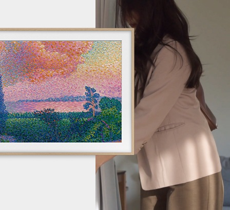 벽에 TV가 설치되어 있으며, 화면에는 명화가 보여지고 있습니다. TV 뒤에는 문을 열고 있는 여성이 있습니다.