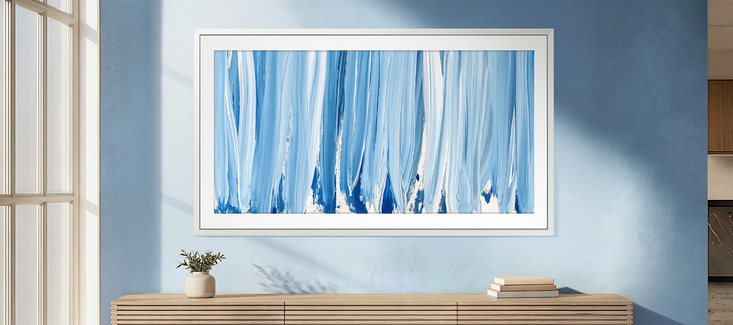 푸른색 벽에 TV가 설치되어 있습니다. TV 아래에는 화분과 책이 놓인 장식장이 있습니다.