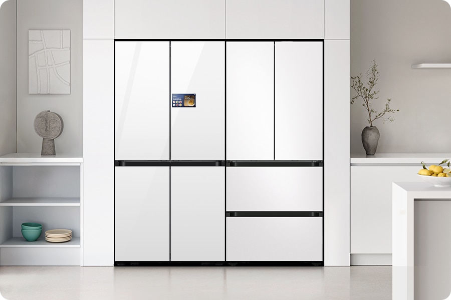 4인 가구. 화이트톤 냉장고장에 냉장고 4도어와 김치플러스 4도어가 페어로 설치되어 있습니다. 냉장고장 좌측 벽면에 그림이 걸려있고 아래 수납장에 그릇 등 오브제가 놓여있습니다. 냉장고장 우측으로는 화이트톤 하부장 위에 화분이 있고 앞쪽에 하얀 식탁 위 레몬이 그릇에 담겨있는 연출된 이미지 입니다.