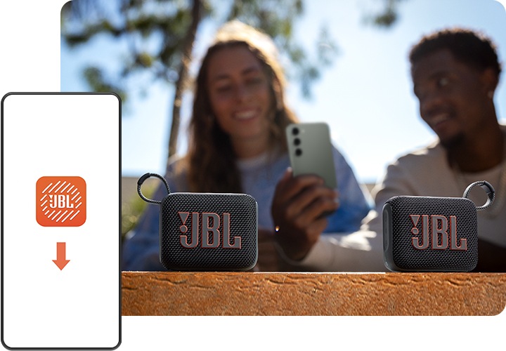 여성과 남성이 벤치에 앉아서 남성이 들고 있는 휴대폰 화면을 바라보고 있습니다. 남성과 여성 앞 테이블에는 스피커 두 대가 놓여 있습니다. 이미지 왼쪽 하단에는 휴대폰 화면이 보이며, 화면에는 JBL 포터블 앱 로고가 있습니다.