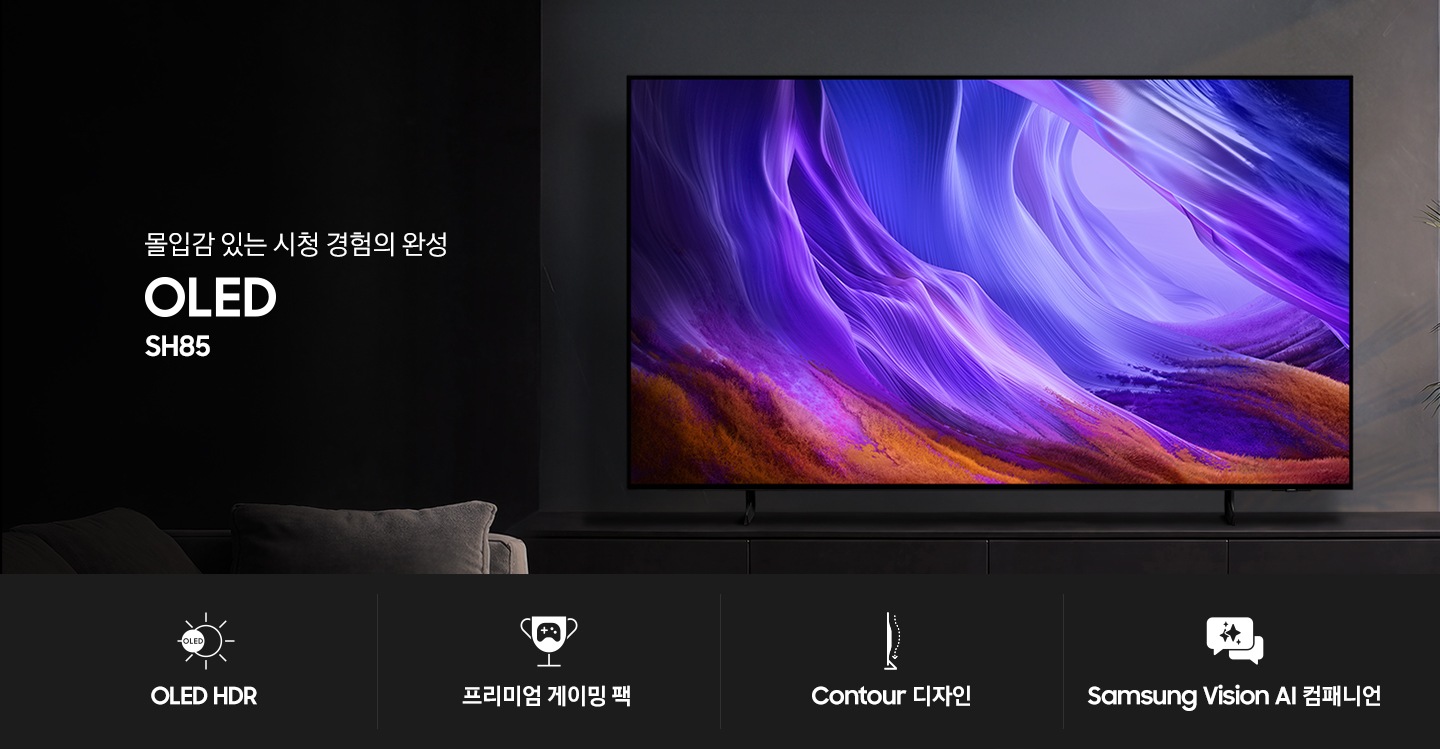 거실 장식장 위에 TV가 설치되어 있습니다. TV 앞에는 소파가 있습니다. TV 왼쪽에는 ‘몰입감 있는 시청 경험의 완성’ 문구와 시리즈명인 ‘OLED’와 모델명인 ‘SH85’ 문구가 기재되어 있습니다. 이미지 하단에는 ‘OLED HDR’, ‘프리미엄 게이밍 팩’, ‘Contour 디자인’, ‘Samsung Vision AI 컴패니언’ 문구와 아이콘이 있습니다.