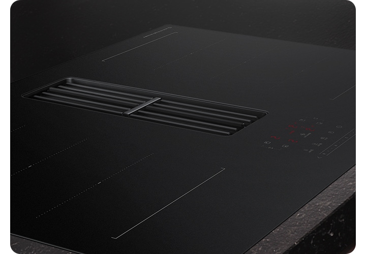 검은색 대리석 상판과 설치되어 있는 후드일체형 인덕션을 확대한 모습입니다.