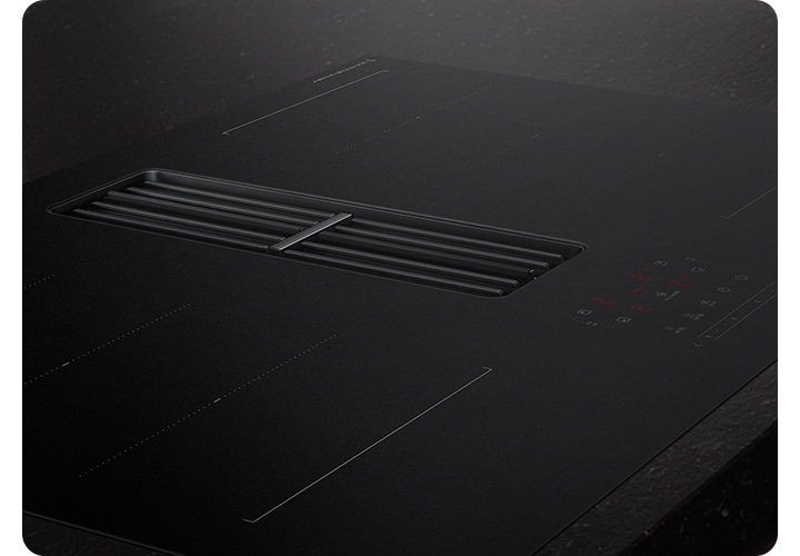 검은색 대리석 상판과 설치되어 있는 후드일체형 인덕션을 확대한 모습입니다.