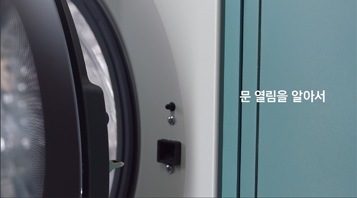 상단 정면에서 BESPOKE 그랑데 AI 원바디 Top-Fit 제품을 촬영한 이미지가 있습니다. 세탁이 완료된 후 문을 살짝 열어 습도를 낮추는 모습입니다.