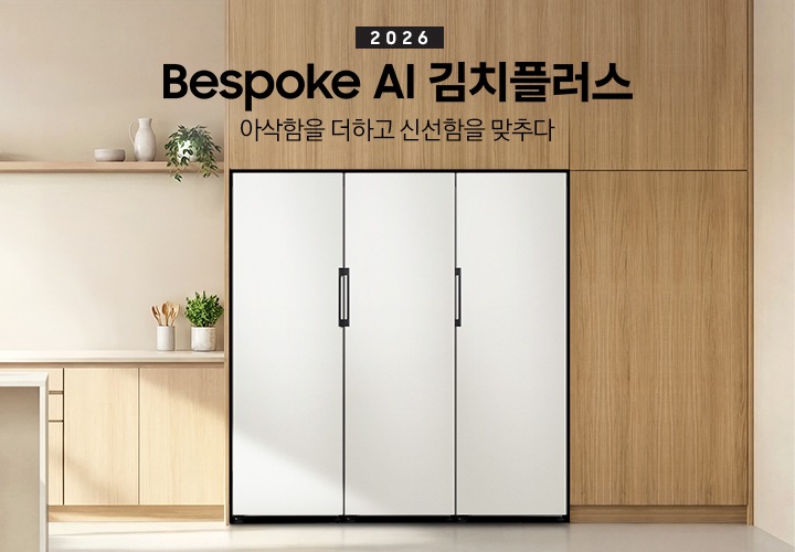 2026 Bespoke AI 김치플러스, 아삭함을 더하고 신선함을 맞추다- 1도어 키친핏 KV 인테리어컷입니다. Bespoke 김치플러스 1도어 제품과 1도어 냉장고, 1도어 냉동고 3개의 제품이 키친핏으로 페어 설치되어 있습니다. 주방은 밝은 베이지 우드로 인테리어 되어있으며, 주방에는 아이보리톤의 아일랜드 식탁, 수전이 설치되어 있습니다. 