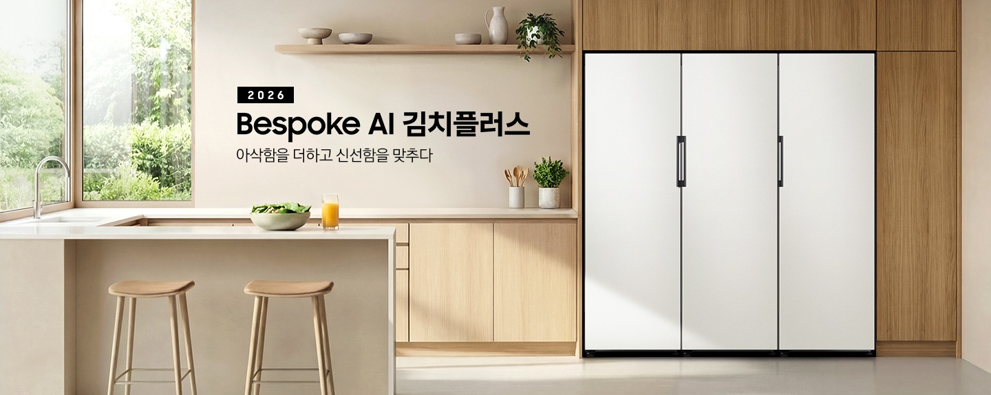 2026 Bespoke AI 김치플러스, 아삭함을 더하고 신선함을 맞추다- 1도어 키친핏 KV 인테리어컷입니다. Bespoke 김치플러스 1도어 제품과 1도어 냉장고, 1도어 냉동고 3개의 제품이 키친핏으로 페어 설치되어 있습니다. 주방은 밝은 베이지 우드로 인테리어 되어있으며, 주방에는 아이보리톤의 아일랜드 식탁, 수전이 설치되어 있습니다. 