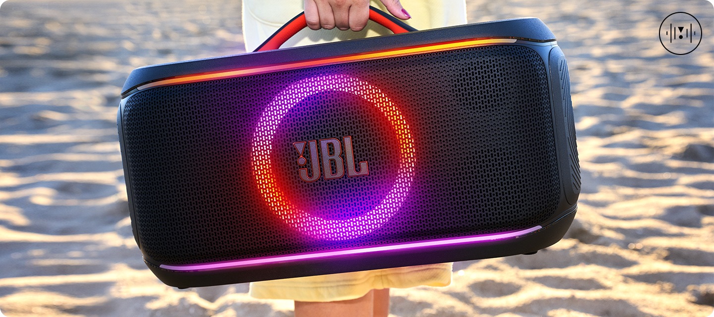 바닷가에서 JBL PARTYBOX ON-THE-GO2 PLUS 제품을 들고있는 연출된 이미지 입니다.