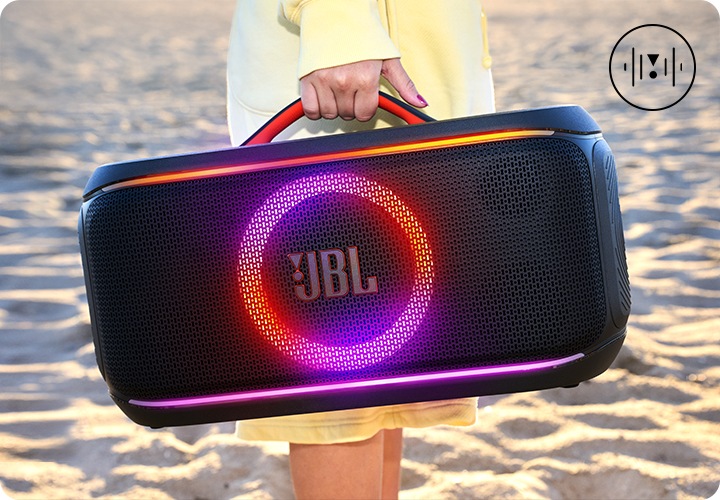 바닷가에서 JBL PARTYBOX ON-THE-GO2 PLUS 제품을 들고있는 연출된 이미지 입니다.