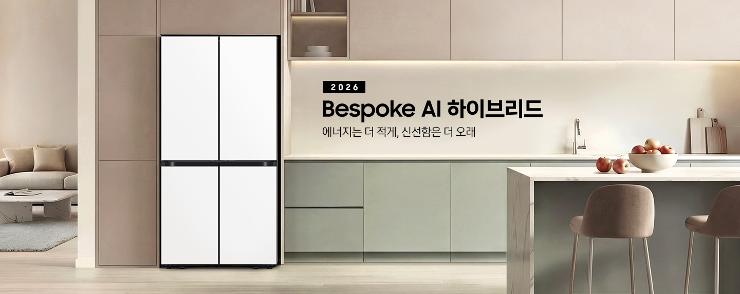 2026 Bespoke AI 하이브리드. 에너지는 더 적게, 신선함은 더 오래. 짙은 베이지색 냉장고장에 새틴 화이트 컬러 냉장고가 설치되어 있습니다. 냉장고 우측으로 그린톤 하부장이 설치되어 있고 앞쪽에 아일랜드 식탁이 있습니다. 식탁 위에는 사과가 든 그릇이 있고 앞에 의자가 놓여있는 연출된 인테리어 이미지입니다.