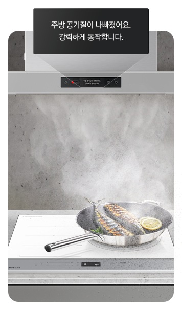 Bespoke 후드 Air 아래의 인덕션 위에 구워진 생선이 올려진 프라이팬에서 연기가 많이 나는 연출 이미지가 있고, Bespoke 후드 Air 디스플레이에 빨갛게 빛나는 LED와 함께 '주방 공기질이 나빠졌어요. 강력하게 동작합니다.'라는 문구가 쓰여있습니다.