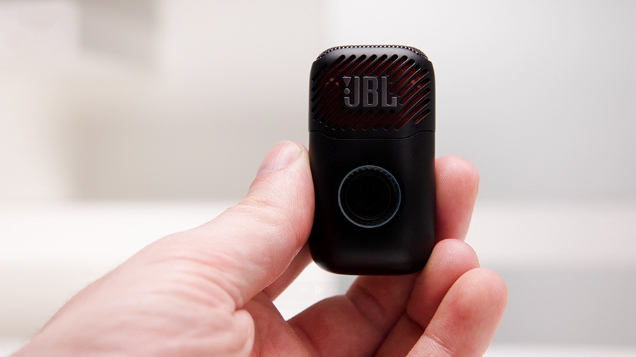 JBL EASYSING MIC MINI 마이크를 조작하는 손이 있습니다. JBL EASYSING MIC MINI 마이크 아래에는 보컬 믹스 레벨이 표시되어 있습니다.