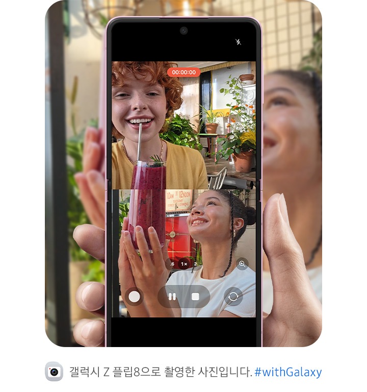 갤럭시 Z 플립8이 펼쳐져 있습니다. 메인 디스플레이에서 사용자와 피사체가 똑같은 포즈를 취하는 모습이 상하 분할 화면으로 나타나며 듀얼 레코딩 영상이 표시되어 있습니다. 