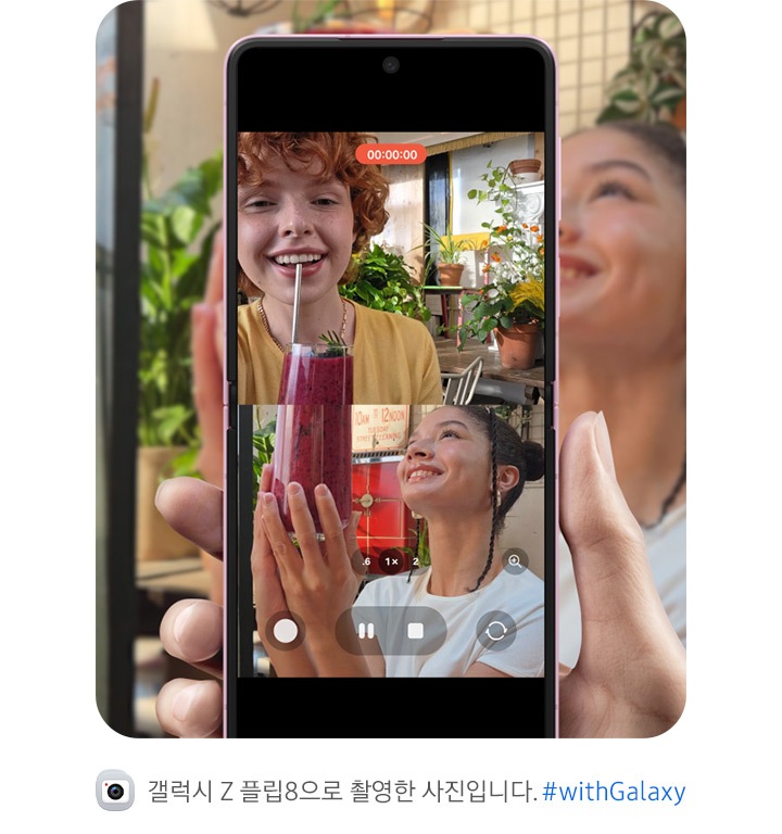 갤럭시 Z 플립8이 펼쳐져 있습니다. 메인 디스플레이에서 사용자와 피사체가 똑같은 포즈를 취하는 모습이 상하 분할 화면으로 나타나며 듀얼 레코딩 영상이 표시되어 있습니다. 