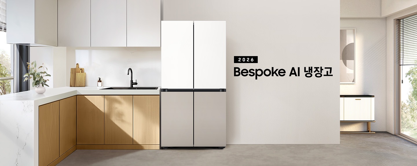 2026 Bespoke AI 냉장고 인테리어컷 입니다. 벽면에 4도어 냉장고가 설치되어 있고 우측으로는 벽 뒤 액자와 테이블이 나와있습니다. 냉장고 좌측으로는 화이트톤 상부장과 우드톤 하부장 위 수전이 설치되어 있고 도마 등 오브제가 놓여있습니다.