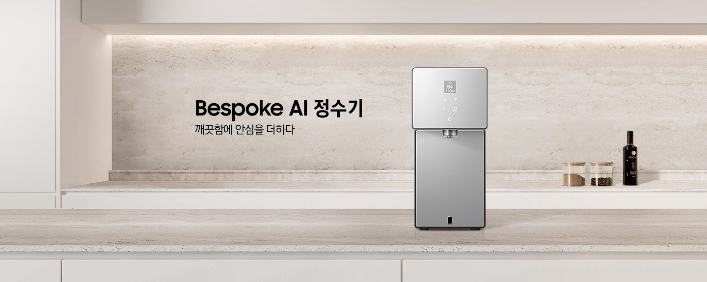 Bespoke AI 정수기. 깨끗함에 안심을 더하다. 화이트톤 주방에 대리석 상판 아일랜드 식탁이 있고 그 위에 Bespoke 정수기 카운터탑 제품이 설치되어 있습니다. 정수기 뒤쪽 하부장 상판 대리석 위에는 조미료와 와인병이 놓여있는 연출된 이미지 입니다.