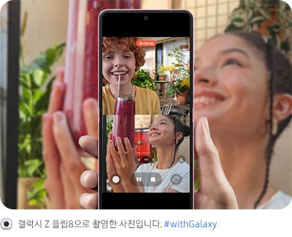 갤럭시 Z 플립8이 펼쳐져 있습니다. 메인 디스플레이에서 사용자와 피사체가 똑같은 포즈를 취하는 모습이 상하 분할 화면으로 나타나며 듀얼 레코딩 영상이 표시되어 있습니다. 