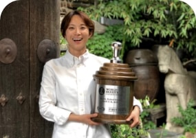 [월드 바리스타가 바르스타 우승 상패를 들고있는 모습]