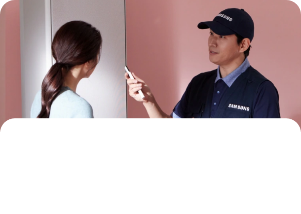 핑크색 벽 앞에서 에어컨 리모콘을 들고 있는 설치기사와 사람이 마주보고 대화하고 있는 모습