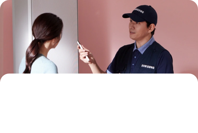 핑크색 벽 앞에서 에어컨 리모콘을 들고 있는 설치기사와 사람이 마주보고 대화하고 있는 모습