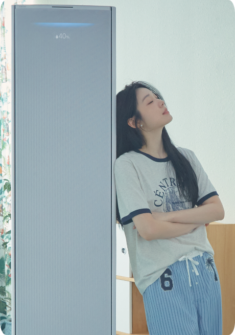 [연예인 김연아가 Bésp~óké Á~Í 무풍콤보 갤러리 제품 옆에서 눈을 감고 팔짱을 낀 채 기대고 있는]