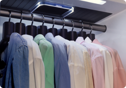 옷걸이에 색상별 셔츠가 여러벌 걸려있는 이미지