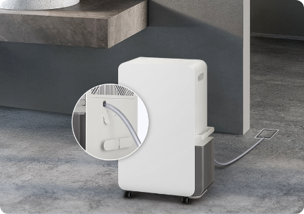 그레이색 바닥에 제습기가 놓여있으며, 제습기 뒷면 배수 캡을 확대한 컷이 함께 노출되어 있는 이미지