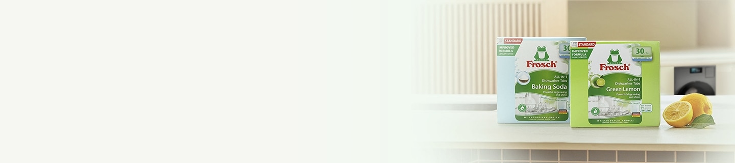 주방 풍경, 테이블에 놓인 프로쉬 식기세척기세제 베이킹소다 제품, 프로쉬 식기세척기세제 그린레몬 제품, 통레몬과 반 잘린 레몬, 테이블 뒤 주방 하부장에 설치된 Bespoke AI 세탁기
