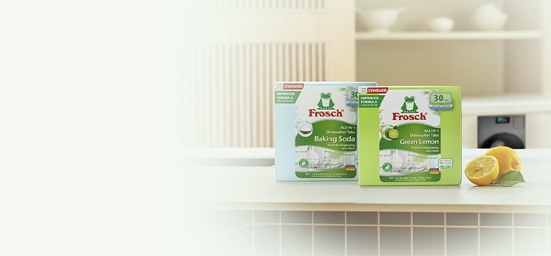 주방 풍경, 테이블에 놓인 프로쉬 식기세척기세제 베이킹소다 제품, 프로쉬 식기세척기세제 그린레몬 제품, 통레몬과 반 잘린 레몬, 테이블 뒤 주방 하부장에 설치된 Bespoke AI 세탁기