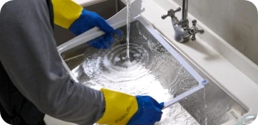 냉장고 선반을 싱크대에서 세척하고 있는