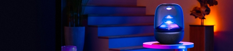 어두운 조명 아래 흰색 테이블 위에 놓여진 하만카돈 AURA STUDIO 5