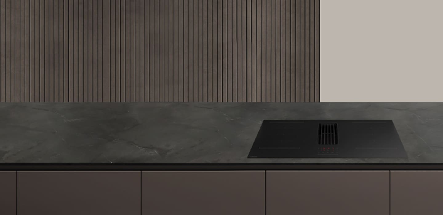 베이지색 대리석 바닥과 벽에 우드톤의 맞춤장과 키친핏 냉장고, 싱크장 안에 빌트인 식기세척기 신제품과 전자레인지 화이트 컬러가 놓여 있고, 라탄 재질의 장과 우드 벽선반에 나무로된 오브제와 도자기와 환풍기가 있는