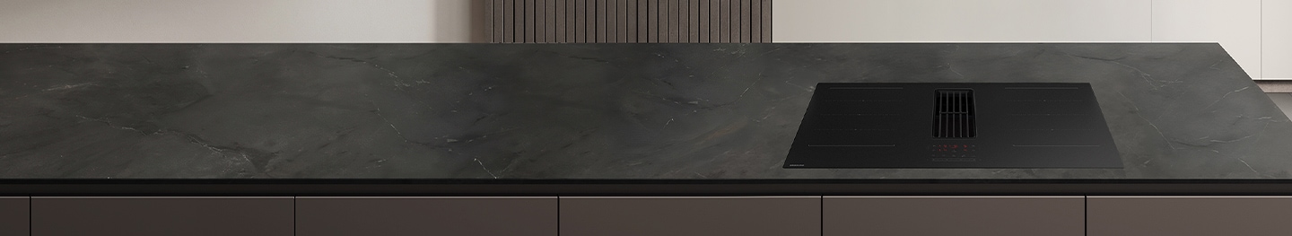 베이지색 대리석 바닥과 벽에 우드톤의 맞춤장과 키친핏 냉장고, 싱크장 안에 빌트인 식기세척기 신제품과 전자레인지 화이트 컬러가 놓여 있고, 라탄 재질의 장과 우드 벽선반에 나무로된 오브제와 도자기와 환풍기가 있는