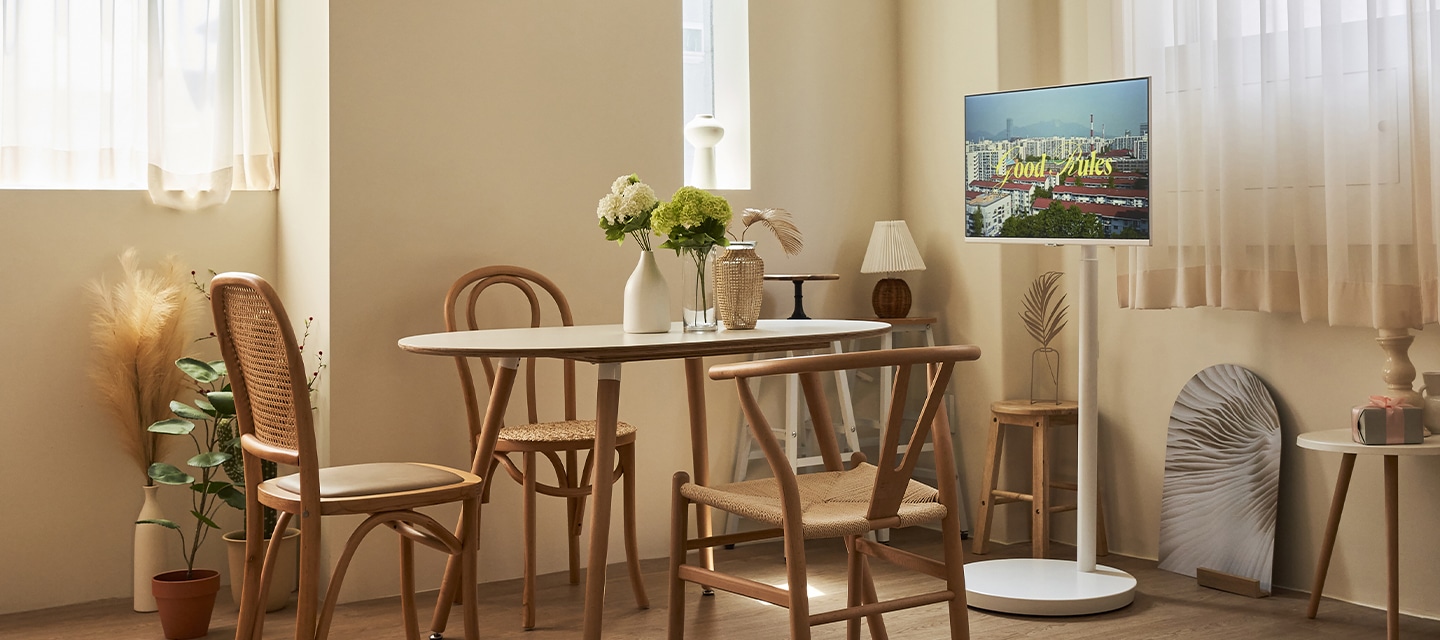 무빙 스탠드 화이트 인테리어컷 티테이블과 의자 옆에 모니터와 무빙스탠드 결합 이미지