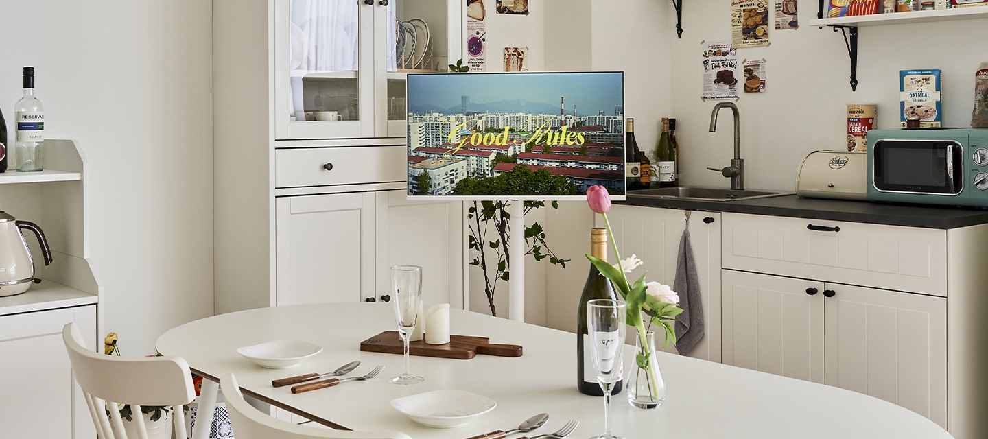 무빙 스탠드 화이트 인테리어컷 식탁과 주방 싱크대 사이제 있는 무빙스탠드와 모니터의 결합 이미지