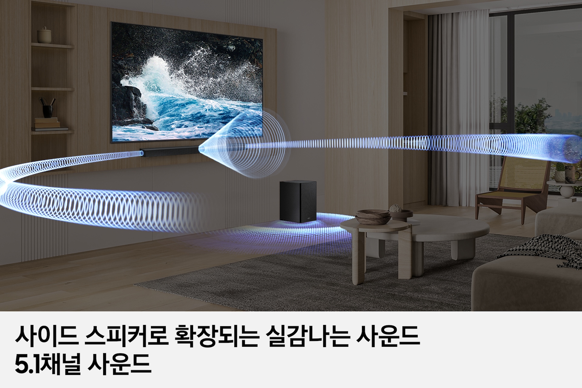 거실 벽에 TV와 사운드바가 놓여 있으며, 우측 하단에는 서브우퍼가 놓여 있습니다. 사운드바와 서브우퍼에서는 음향효과가 나오고 있습니다. 이미지 하단에는 '사이드 스피커로 확장되는 실감나는 사운드 5.1채널 사운드' 문구가 기재되어 있습니다.
