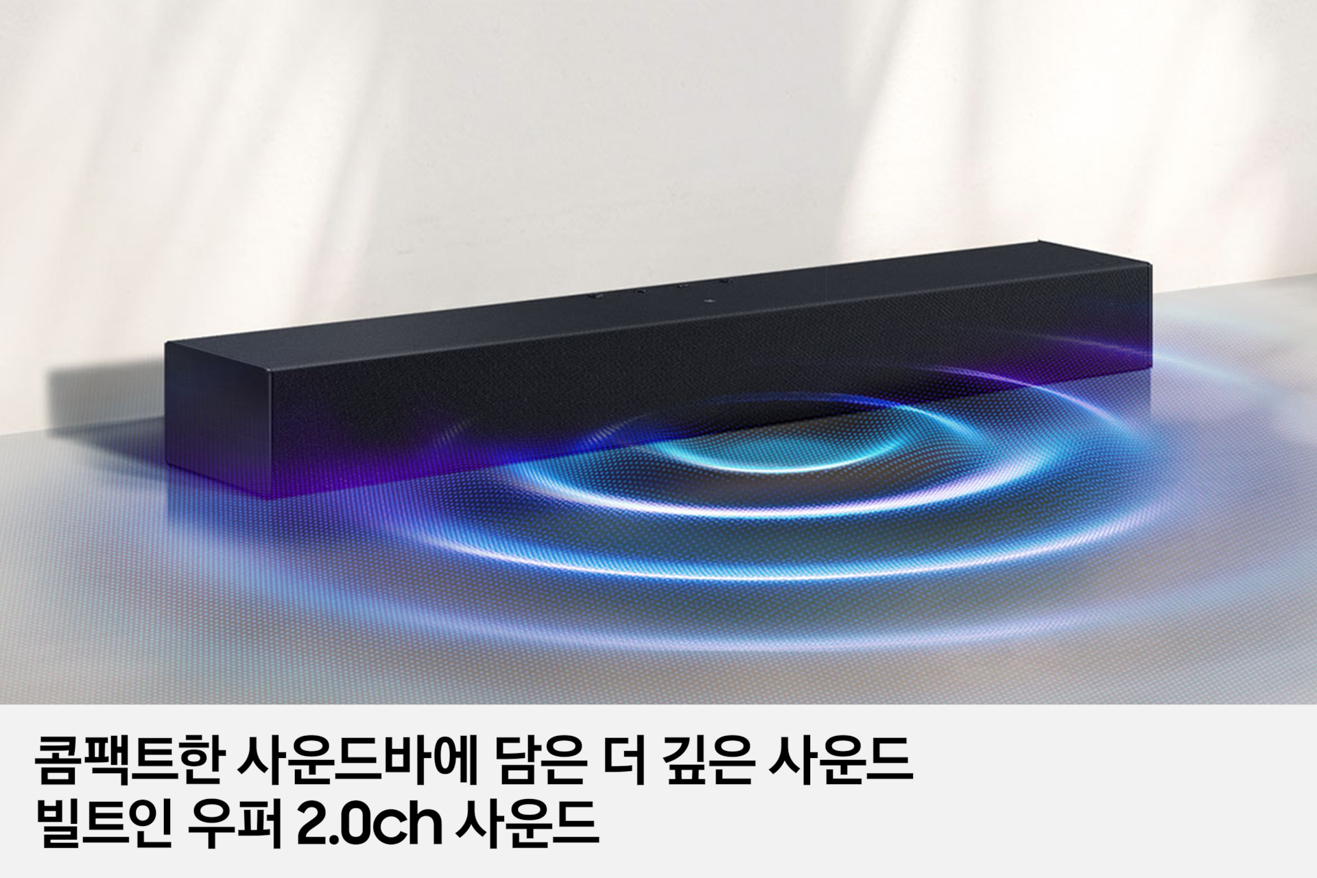 사운드바가 바닥에 놓여 있으며, 사운드바에서 음향효과가 나오고 있습니다. 이미지 하단에는 '콤팩트한 사운드바에 담은 더 깊은 사운드 빌트인 우퍼 2.0ch 사운드' 문구가 기재되어 있습니다.