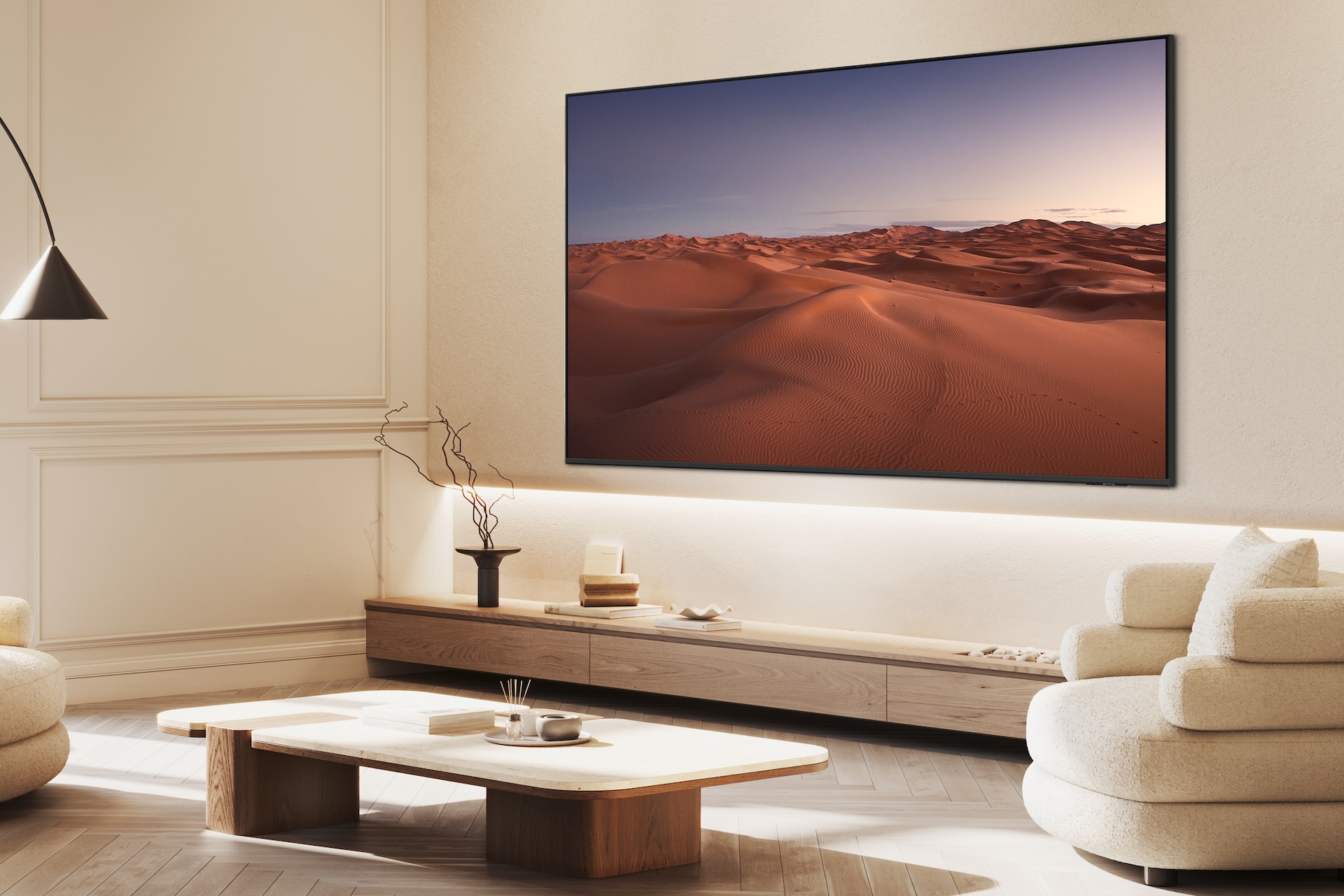 2025 QLED 4K QF6A (214cm) 세번째 이미지이며, 거실 벽에 TV가 설치되어 있습니다. TV 아래에는 장식장이 있으며, 위에는 장식품들이 놓여 있습니다. TV 앞에는 테이블과 소파가 보이는 라이프스타일 컷입니다.