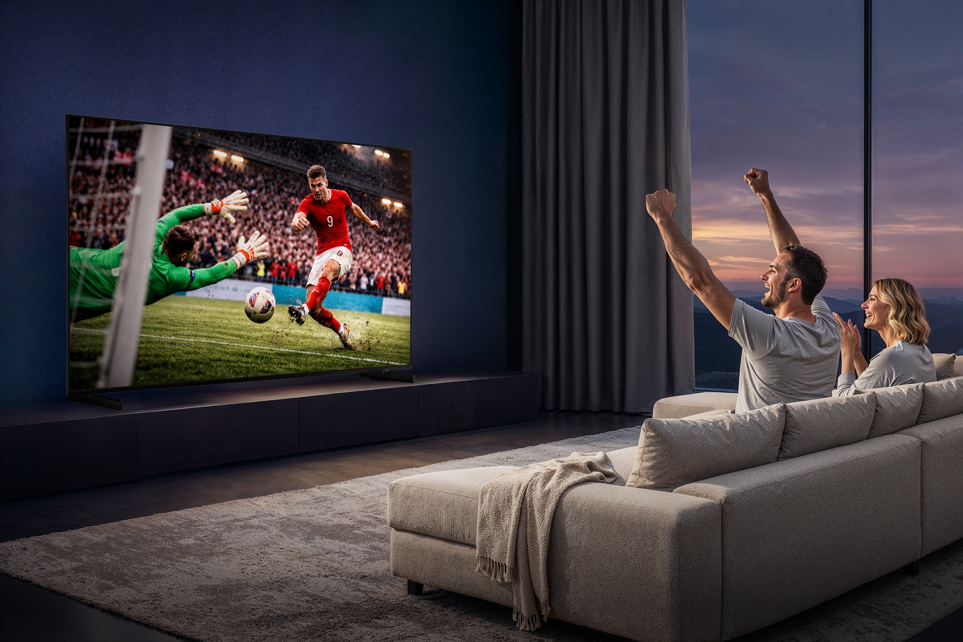 거실 장식장 위에 TV가 설치되어 있습니다. TV 화면에는 축구 경기 중입니다. TV 앞 소파에 앉은 남성이 TV를 보며 환호하고 있습니다. 