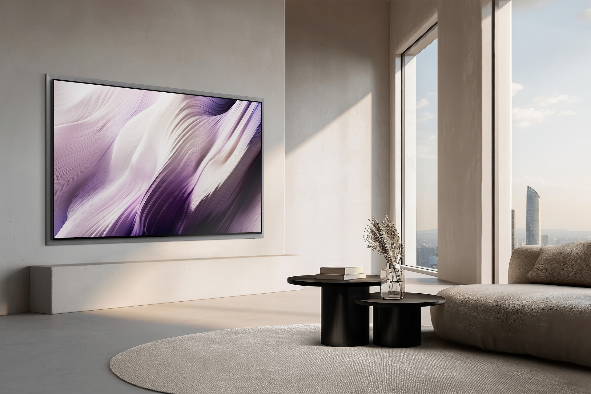 벽에 TV가 설치되어 있으며, TV의 좌측면이 보입니다. TV 앞에는 책들이 올려진 테이블과 소파들이 있습니다.