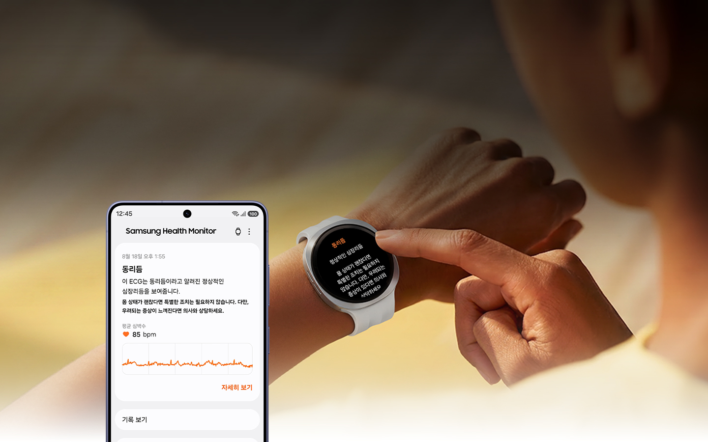 한 여성이 갤럭시 워치를 만지고 있습니다. 워치 화면에는 '동리듬'이라는 심전도(ECG) 측정 결과와 함께 하단에 정상 심장리듬 등의 세부 안내 문구가 표시되어 있습니다. 주변에는 동리듬에 대한 상세 정보와 그래프가 표시된 스마트폰의 삼성 헬스 모니터 앱 화면이 함께 놓여 있습니다.
