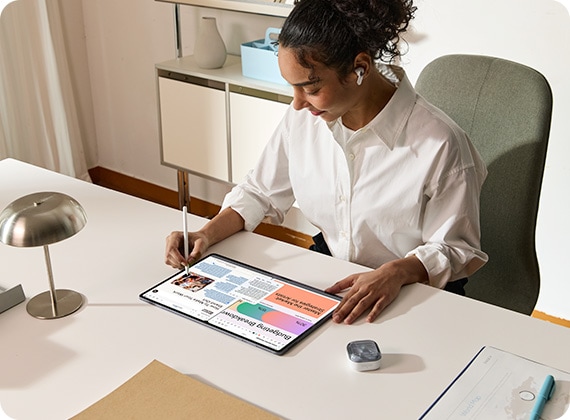 갤럭시 버즈4 프로를 착용한 사람이 갤럭시 탭 S11 울트라에서 S펜을 사용하고 있고 화면에 글쓰기 어시스트를 활용한 텍스트를 강조하고 있습니다. 갤럭시 버즈 케이스가 근처에 놓여져 있습니다.