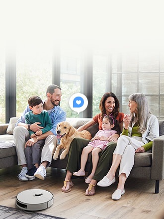소파에 앉아 있는 다섯 명의 가족과 반려견 앞에서 그레이 색상의 삼성 Bespoke AI Jet Bot이 바닥을 청소하고 있으며 중앙에 하트 아이콘이 표시됨