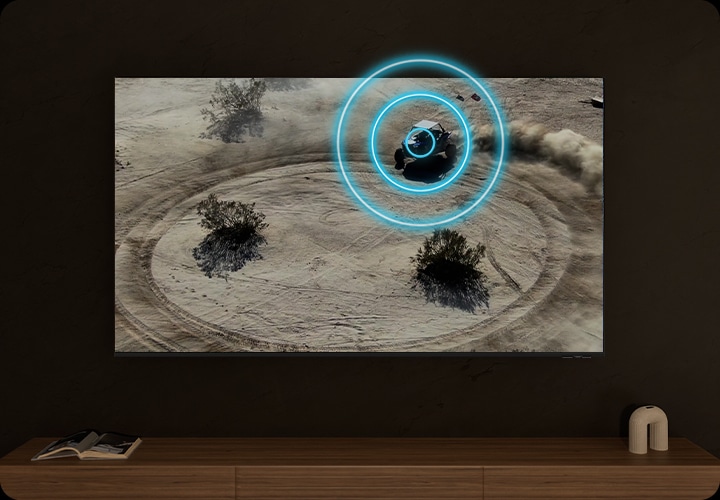 TV 화면에는 사막에서 원을 그리며 오토바이를 타고 움직이는 사람이 있습니다. 오토바이가 움직이는 방향에 따라 먼지가 발생하고 있습니다.