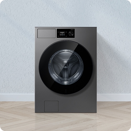 엷은 분홍색 벽과 흰 바닥으로 된 공간입니다. 엷은 분홍색 벽 중간 앞에 세탁기가 있는 이미지입니다.