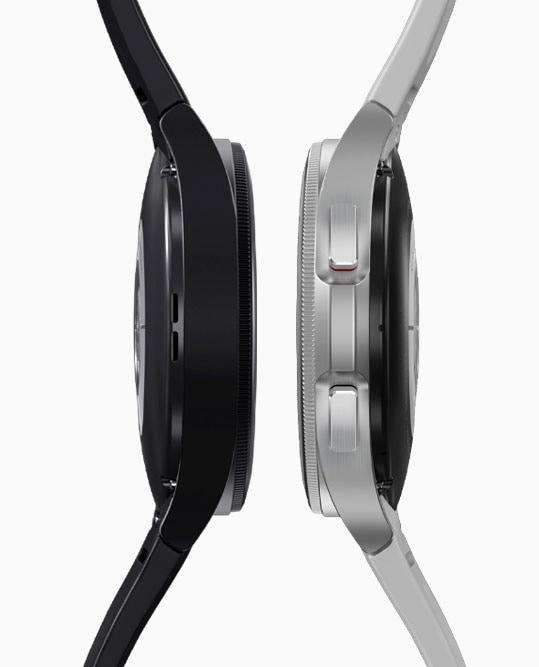 Dos dispositivos Galaxy Watch4 Classic, negro a la izquierda y plateado a la derecha, se colocan uno al lado del otro en una vista lateral.