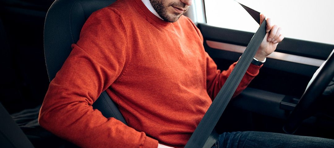 Image of a man in his car buckling his seat belt. On the side is the Activated actions window and it says Voice wake up on, Play Samsung Music, and auto-rotate Screen orientation.