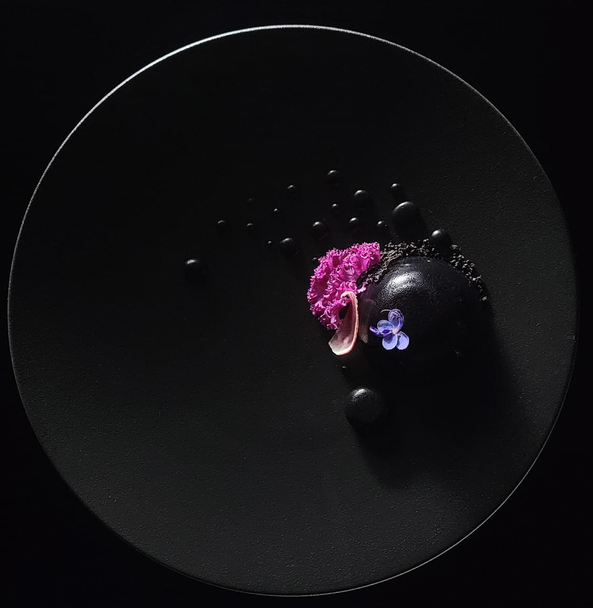 Gros plan de fleurs vibrantes sur une plaque noire avec des lignes de quadrillage sur l'image, prise avec l'appareil photo 108MP du Galaxy S21 Ultra 5G. L'image est recadrée, montrant une résolution nette et des couleurs vives.