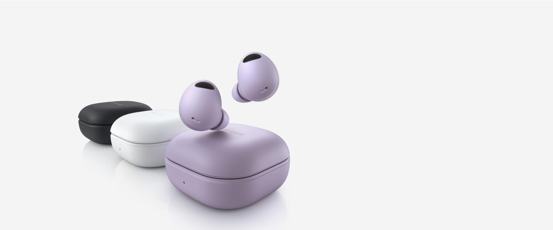 Three Galaxy Buds2 Pro devices are lined up. The Bora Purple Galaxy Buds2 Pro device in the front has two buds hovering above the closed case. The middle White closed case is followed by a Graphite closed Buds2 Pro case.